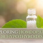 A soft, warm-lit image featuring a small glass vial filled with white homeopathic pellets and a fresh green leaf, set against a gentle bokeh background to symbolize natural healing.